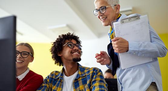 Instructor engaging with her students in front of a computer