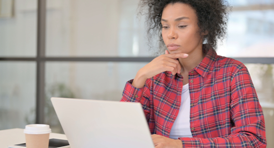 Young woman thinking while looking at a computer screen